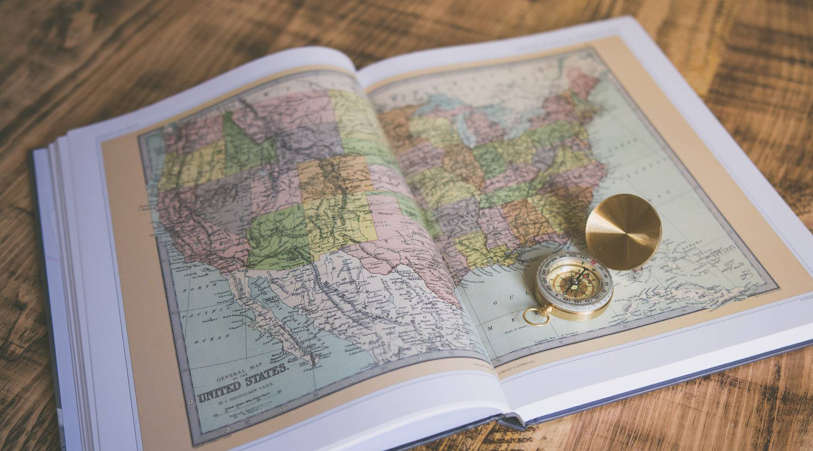 Book opened with US Map and compass placed on top.