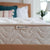 Spindle's organic latex mattress label on mattress with pillows and white blanket on the bed.