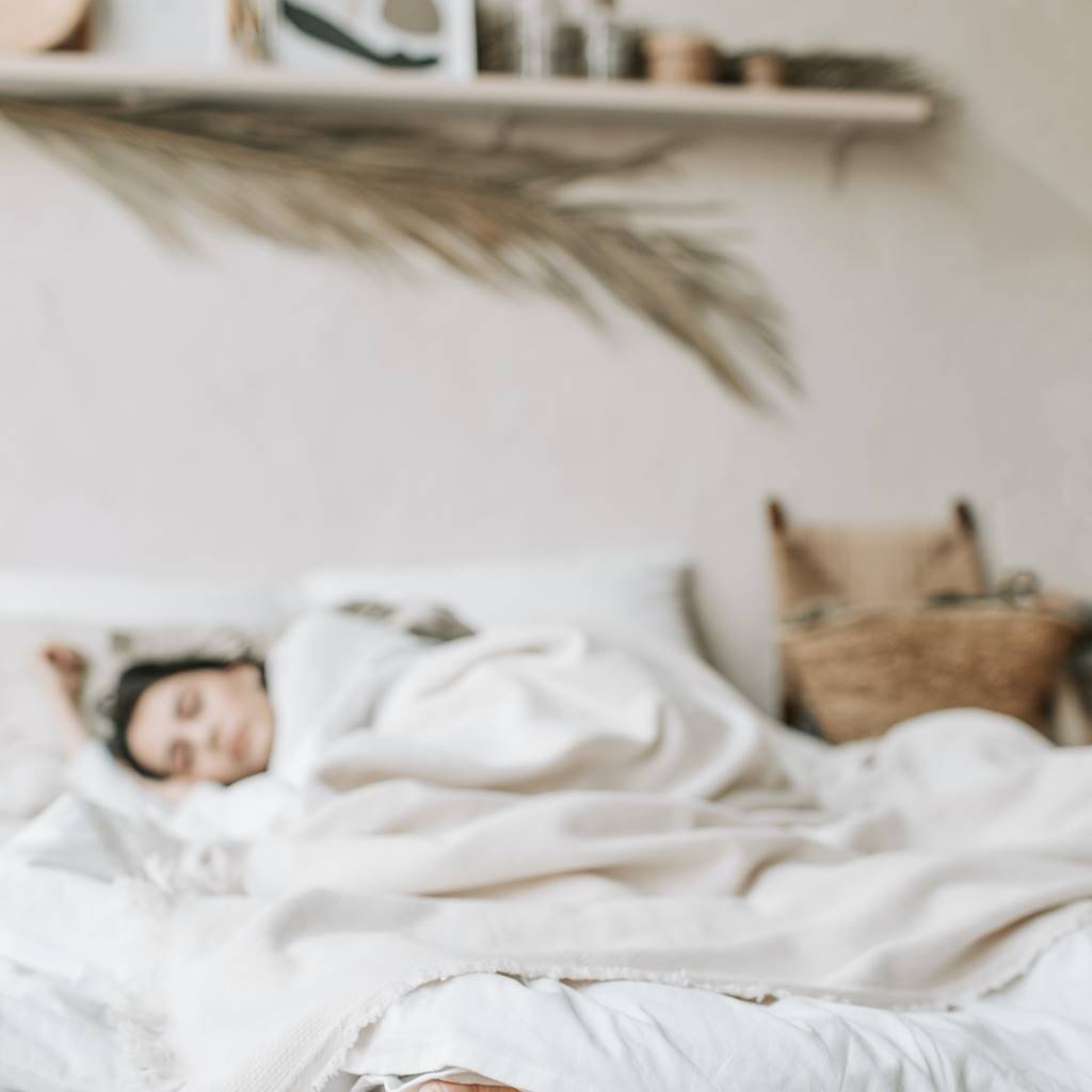 Women asleep on latex mattress with white blankets