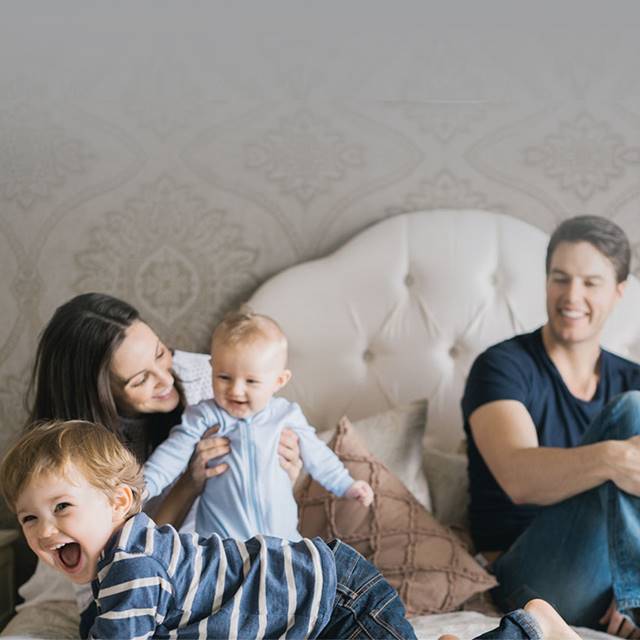 Family with smiling children playing on an organic mattress.