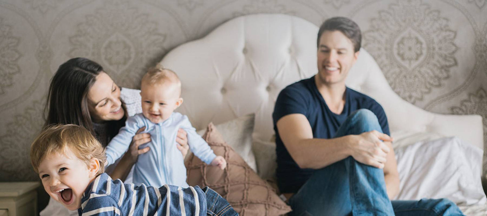 Family with smiling children playing on an organic mattress.